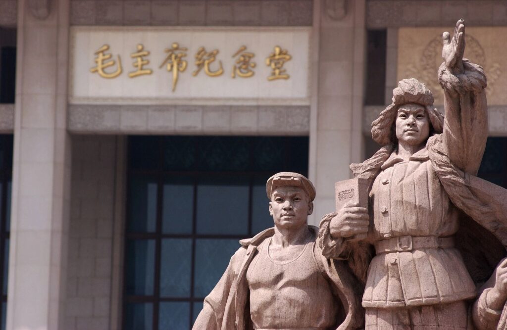 Two statues of men in uniform are standing outside.