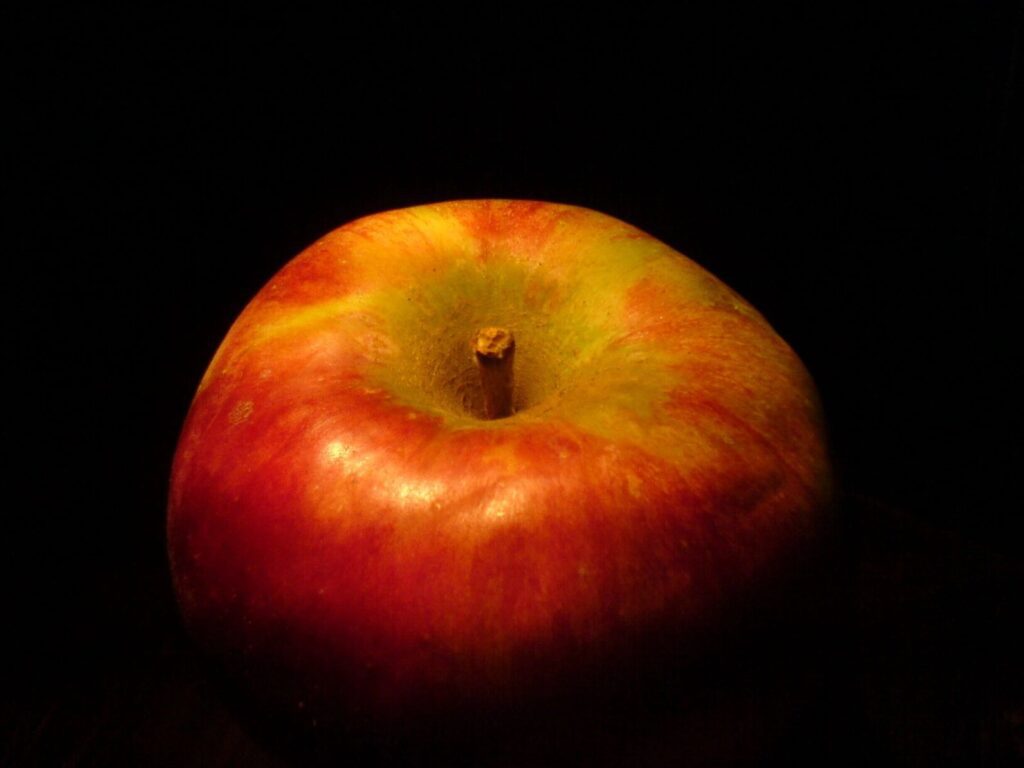 A close up of an apple on a black background